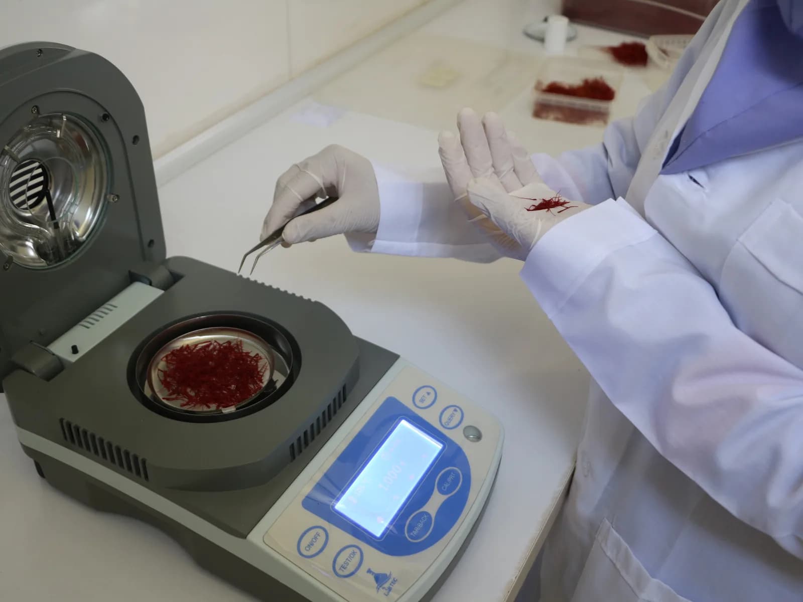 A saffron sample being weighed in a laboratory moisture analyser
